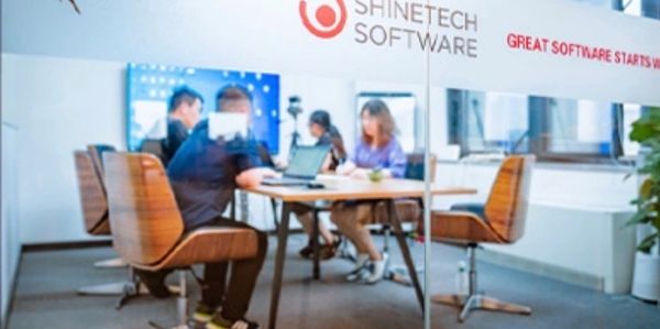 People working in a modern office meeting room at Shinetech Software.