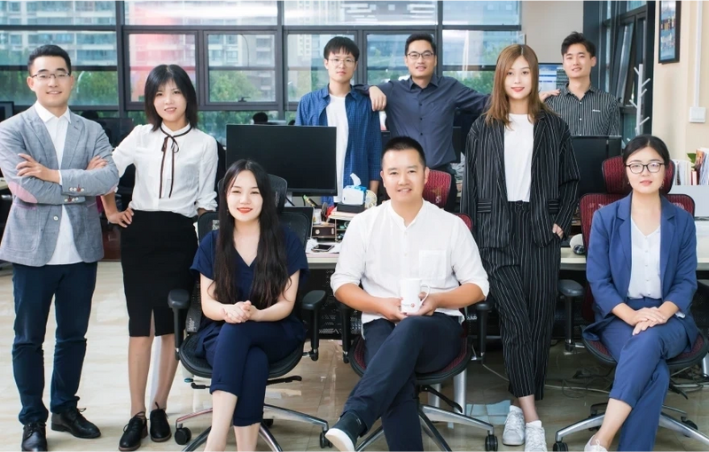 A diverse group of young professionals posing confidently in a modern office.